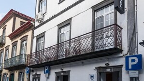 A white building with a red-tiled roof, a sign for a hotel, and multiple parking signs. - Hotel São Miguel (Ponta Delgada)