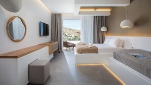 A modern hotel room with a large bed, a desk, a chair, and a view of the landscape. - Lambis Studios & Apartments (Rhodes)