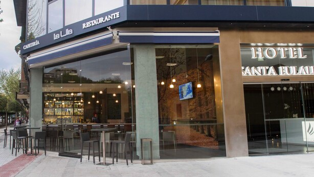 Un hôtel doté d’une façade moderne, d’un bar bien visible avec des places assises et d’une entrée clairement identifiable.