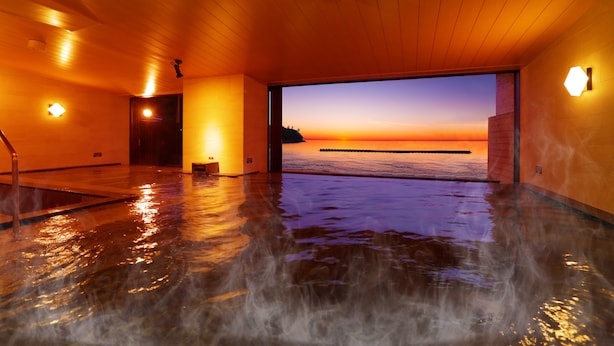 A spa area with a view of the sunset over the water. - Ooedo Onsen Monogatari Toi Marine Hotel (Izu)