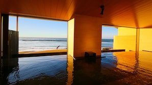 An indoor infinity pool with a view of the ocean. - Ooedo Onsen Monogatari Toi Marine Hotel (Izu)