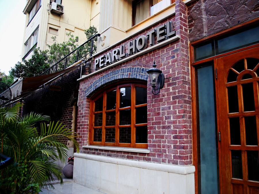 Un hotel con fachada de ladrillo, grandes puertas de madera dobles y un cartel sobre la entrada.