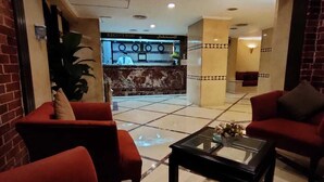 A reception area with a receptionist desk, red sofas, and a glass coffee table.
