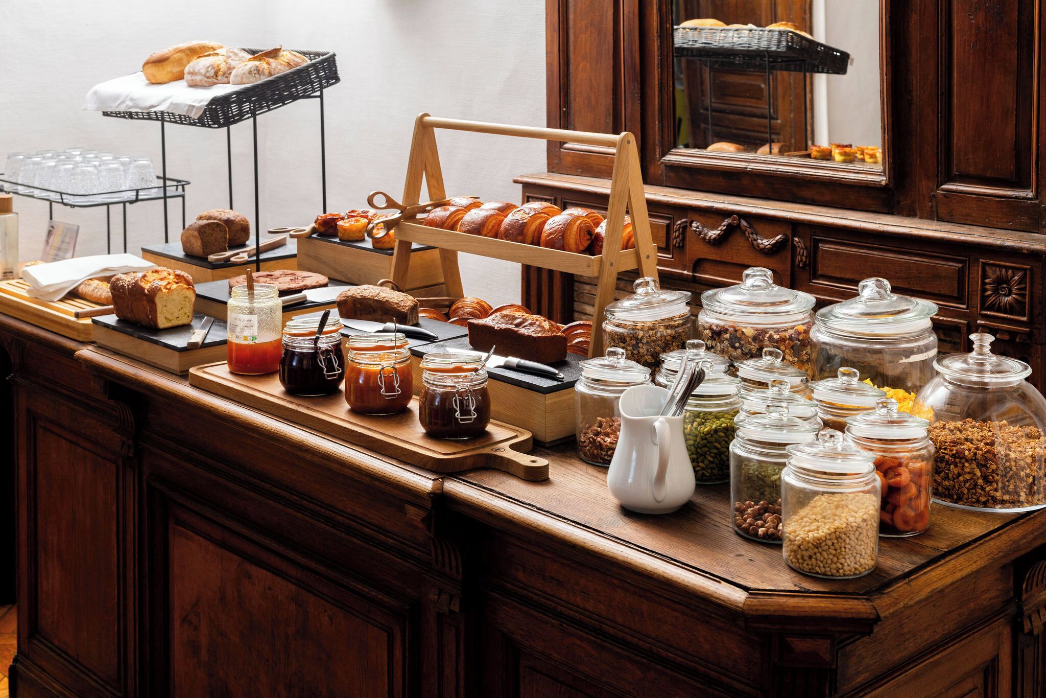 A breakfast buffet with various pastries, breads, and condiments.
