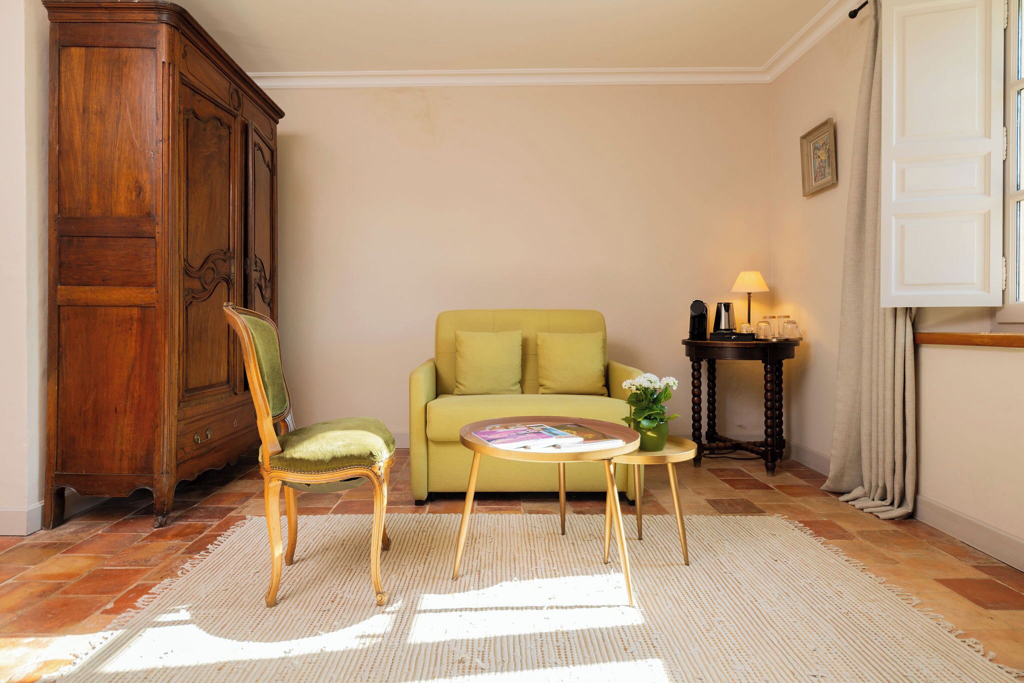 A living room with a sofa, a chair, a coffee table, a cabinet, and a lamp.