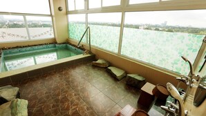 A spa area with a stone floor, a small pool, and a view of a river through large windows. - Super Hotel Yangon Kabar Aye Road (Yangon)