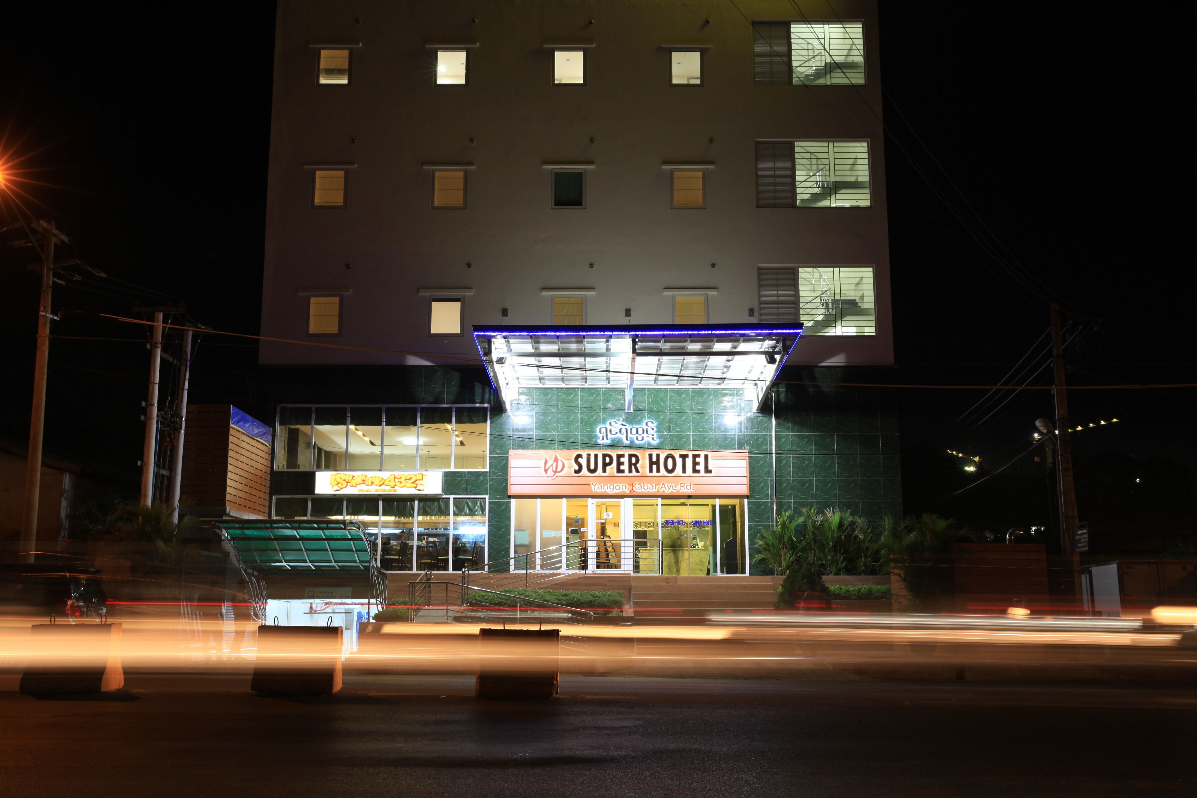 A Super Hotel with a modern facade, multiple windows, and a prominent entrance.