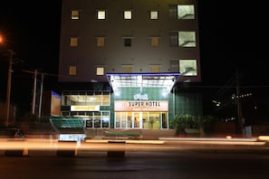 Un hotel moderno con fachada contemporánea, varias ventanas y una entrada destacada.