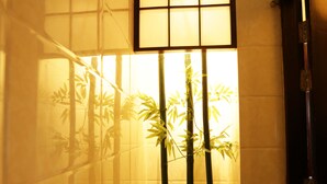 A traditional Japanese room with tatami flooring, a shoji screen, and bamboo plants. - Super Hotel Yangon Kabar Aye Road (Yangon)