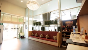 A hotel lobby with a red sofa, a chandelier, and a reception desk. - Super Hotel Yangon Kabar Aye Road (Yangon)