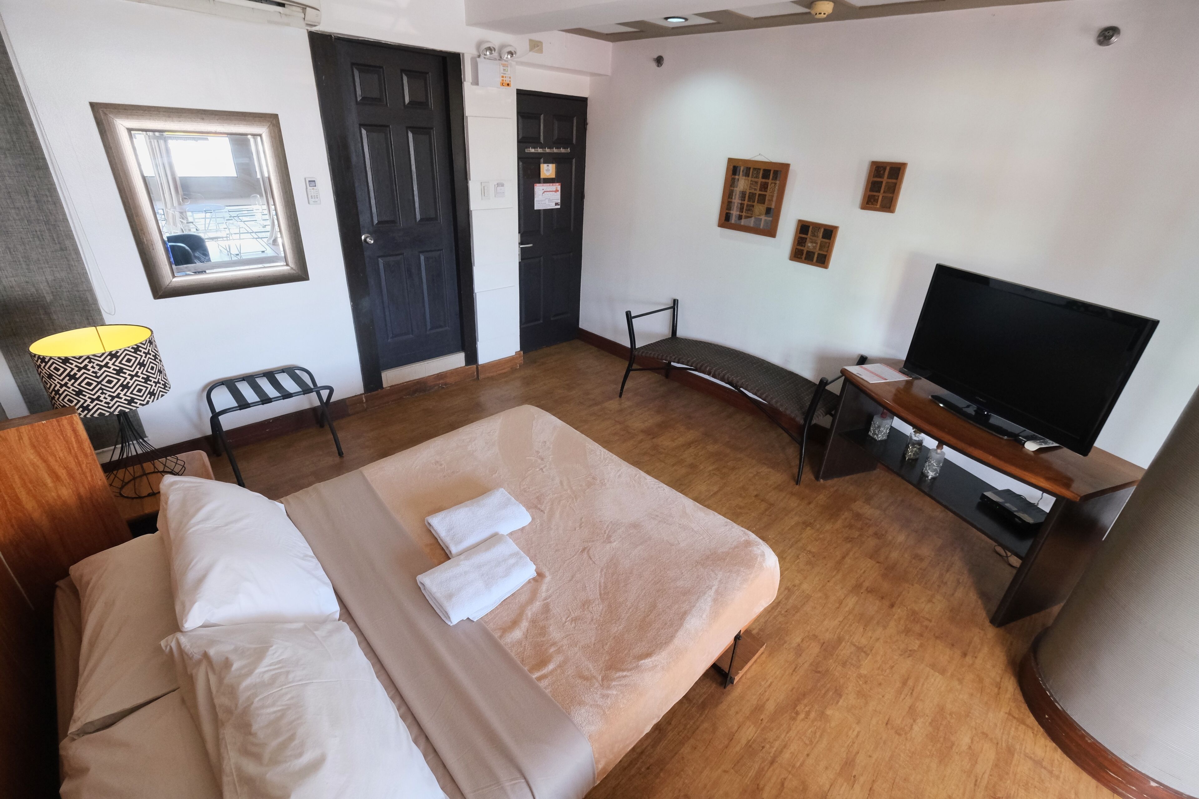 Una camera d'albergo con un letto, una TV, una scrivania e una sedia.