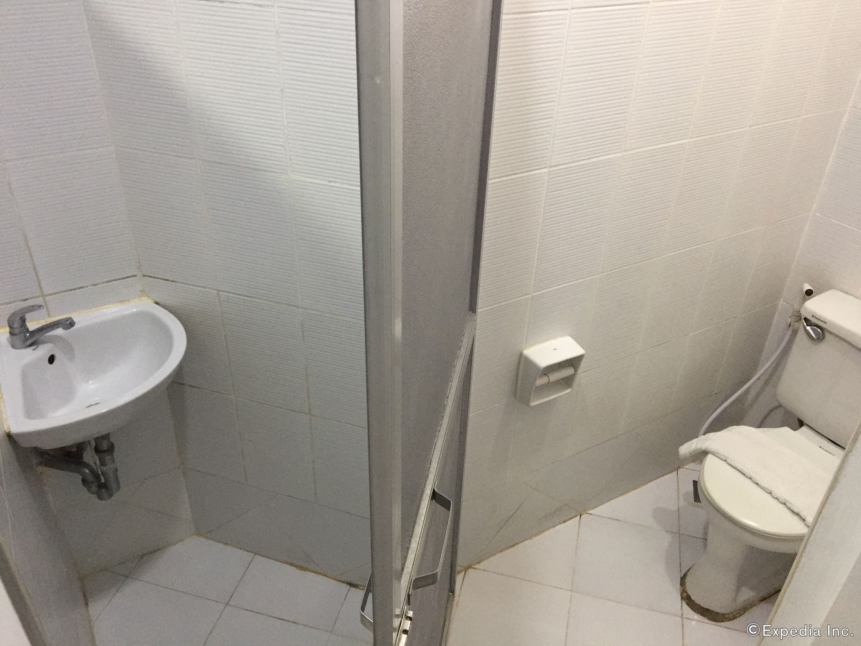 A bathroom with a sink, toilet, and shower stall.