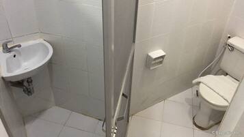 A bathroom with a sink, toilet, and shower stall.