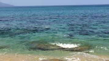 Una playa con aguas turquesas cristalinas y una orilla arenosa.