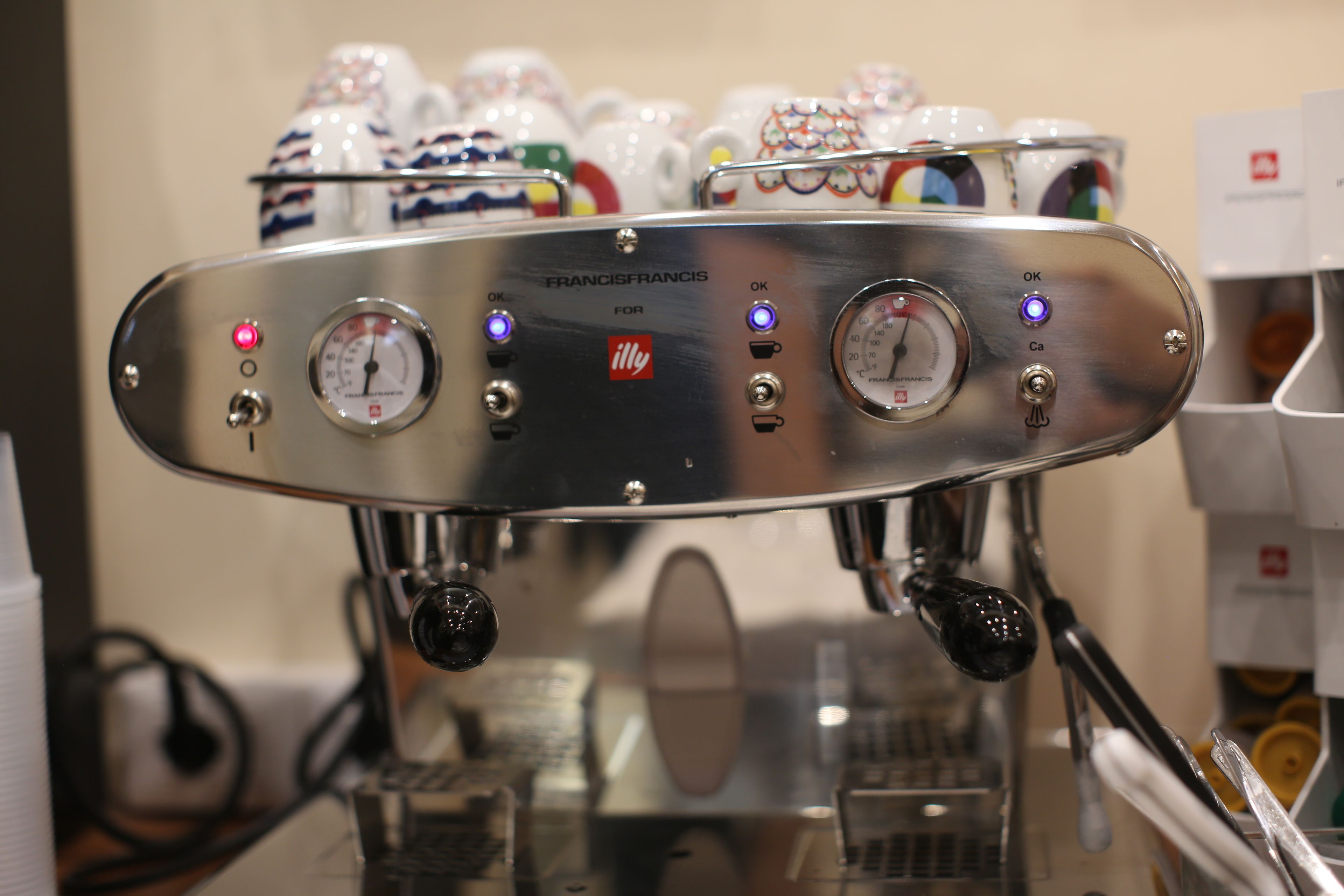 A coffee machine with multiple dials and buttons, including a temperature gauge and a pressure gauge.