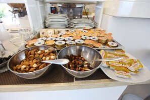 A buffet with various food items including nuts, fruits, and packaged snacks. - Hotel Eubea (Reggio Calabria)