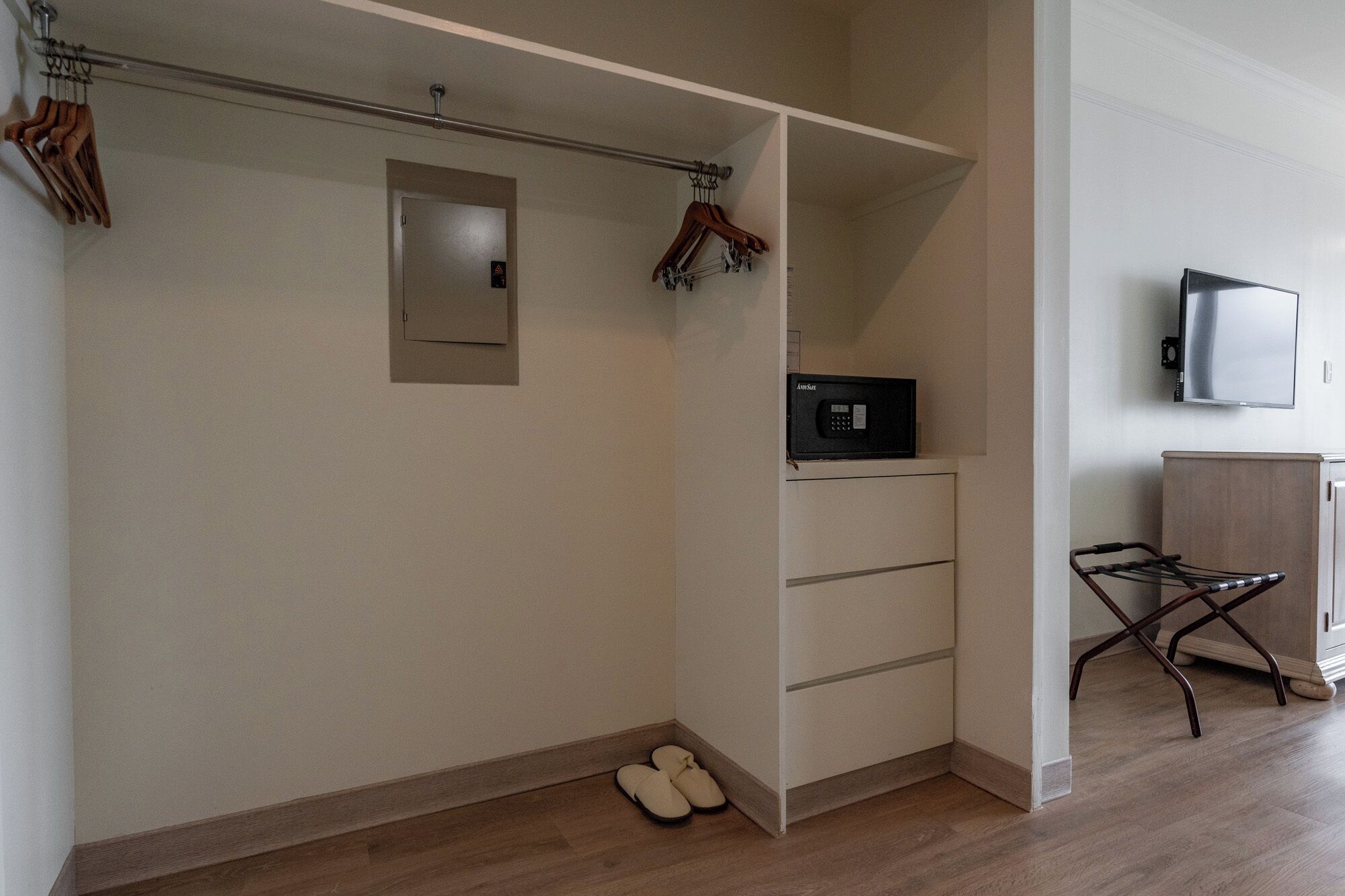 Un dressing avec espace pour suspendre les vêtements, un petit espace de rangement et un porte-chaussures.