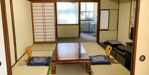 A traditional Japanese room with tatami flooring, a wooden table, and sliding doors. - Beppu no OYADO Kagaya (Beppu)