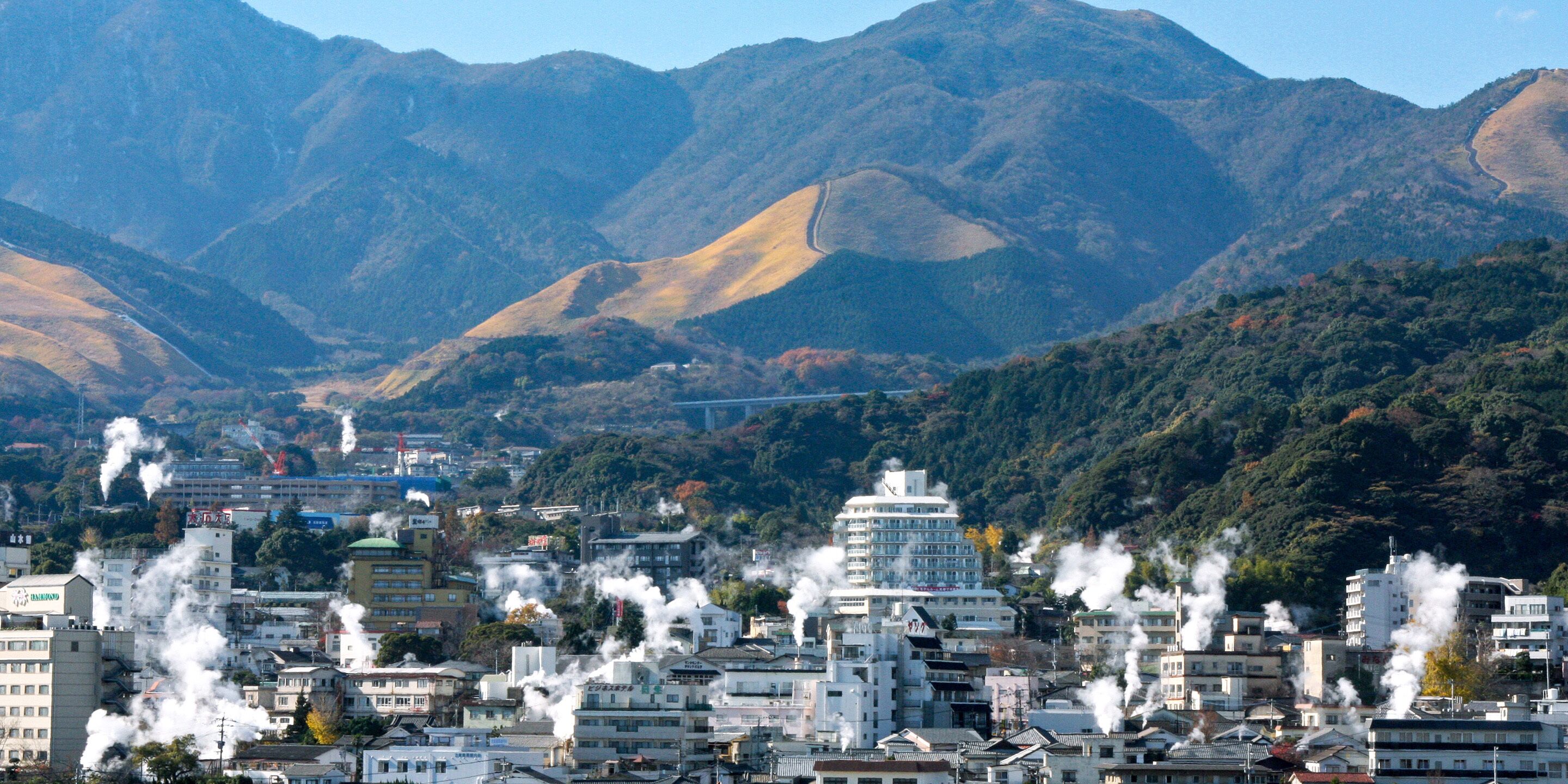 A cityscape with buildings and mountains in the background.