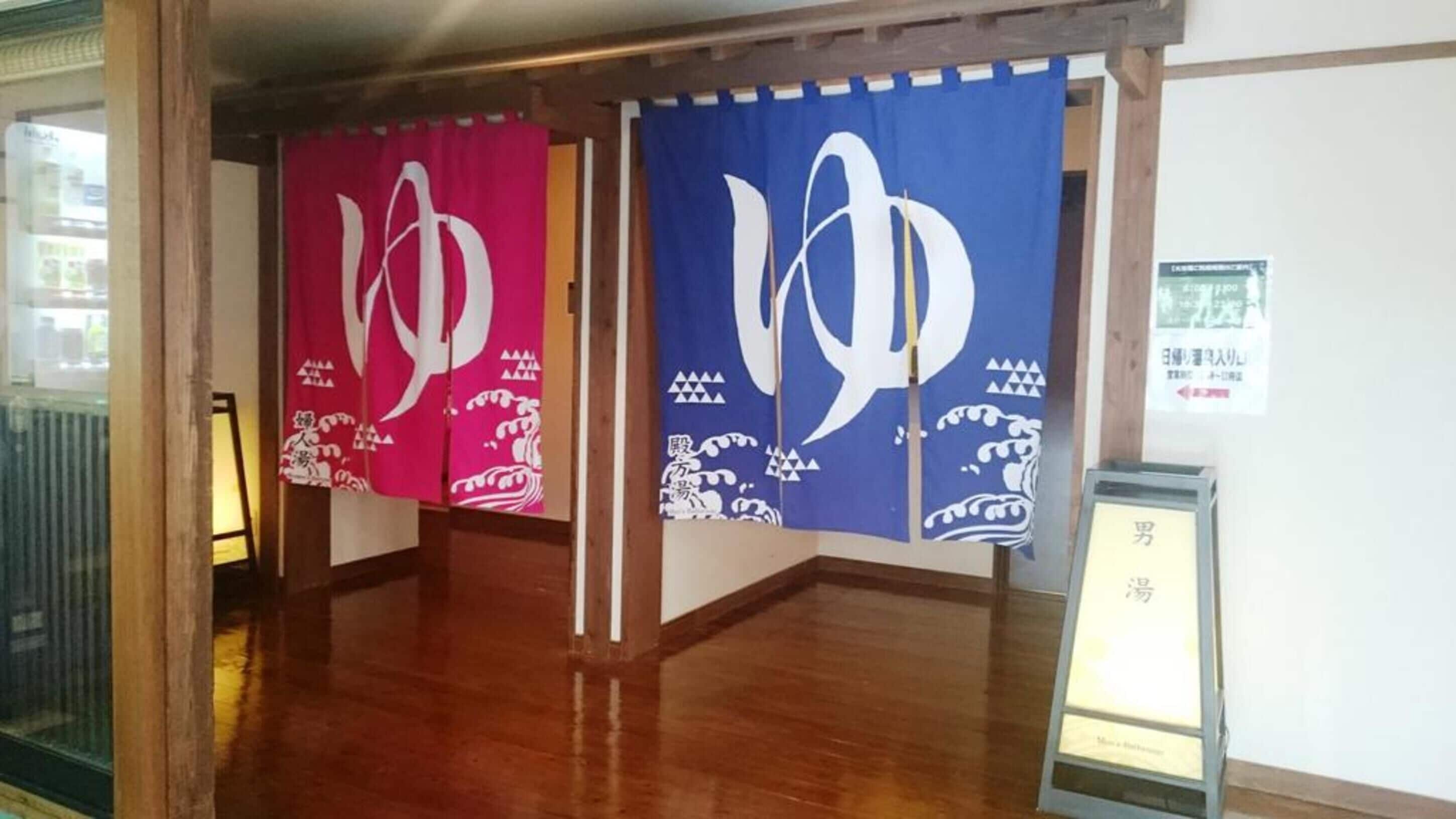 A hallway with wooden flooring and two large banners hanging on the wall.