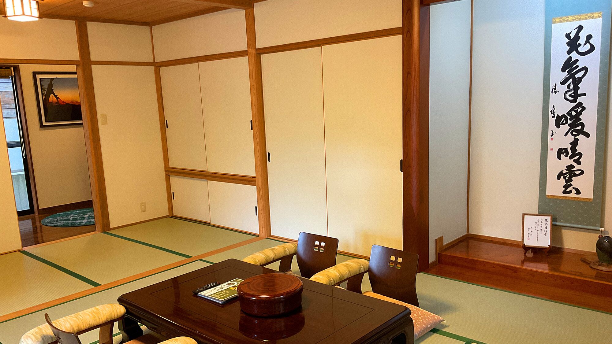 Una habitación tradicional japonesa con suelo de tatami, una mesa de madera baja y una puerta corredera de shoji.