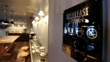 A breakfast lounge area with a bar, stools, and hanging lights.
