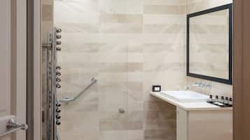 Een moderne badkamer met een douche, wastafel en spiegel.