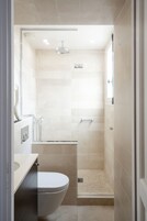 Un bagno moderno con wc, lavandino e zona doccia.