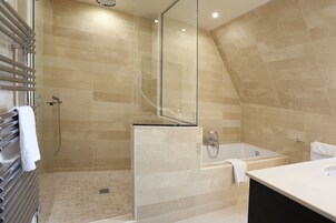 A modern bathroom with a glass-enclosed shower, a freestanding bathtub, and a vanity with a sink.