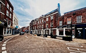 A street with brick buildings, a clear sky, and a road with directional arrows. - The Rose and Crown Hotel (Wisbech)