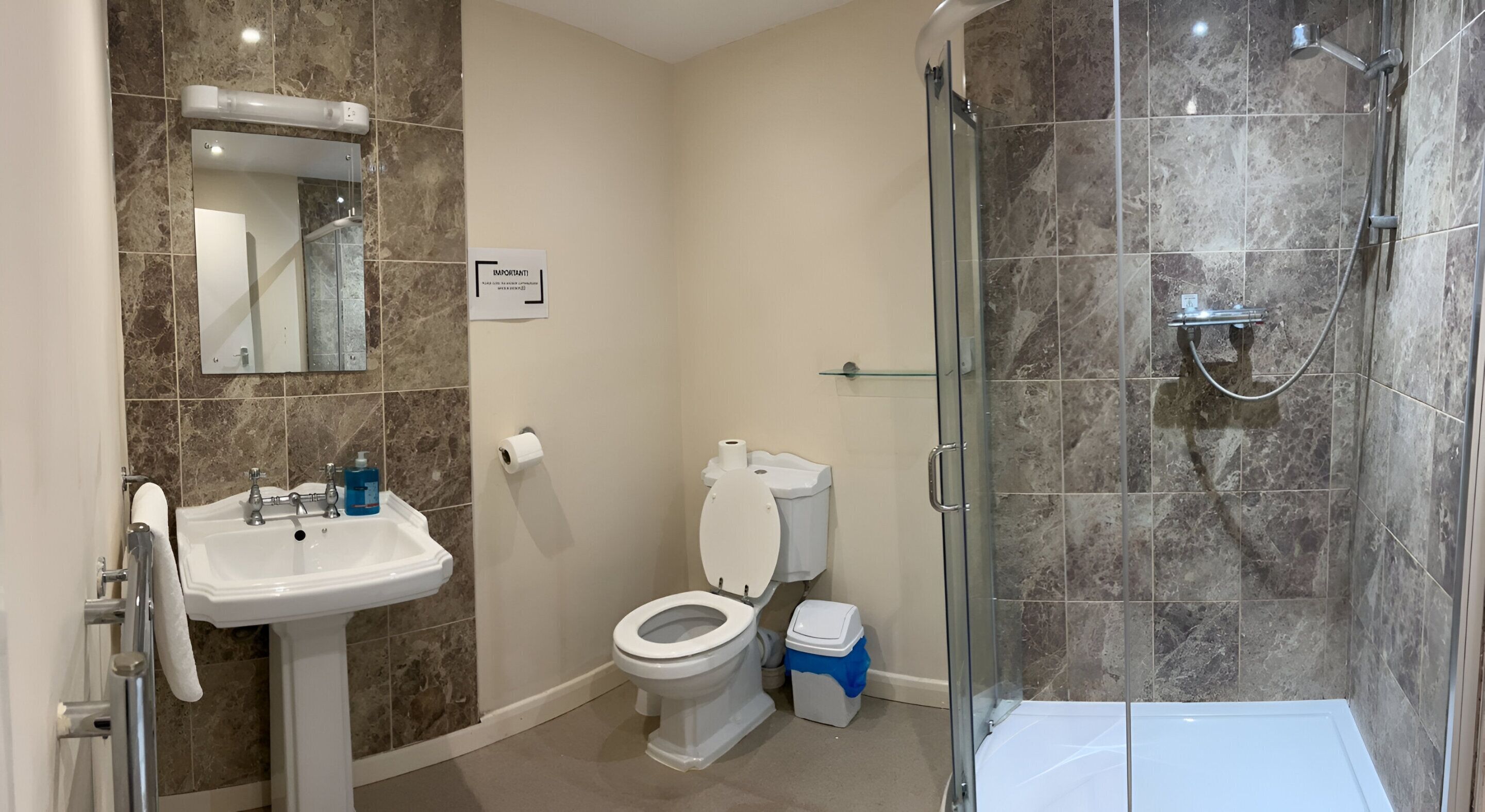 A bathroom with a sink, toilet, and shower.