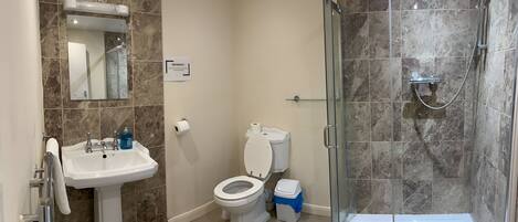 A bathroom with a sink, toilet, and shower.