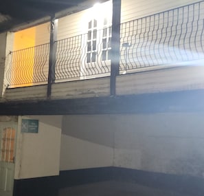 A room with a barred window, a door with a sign, and a concrete wall. - The Rose and Crown Hotel (Wisbech)