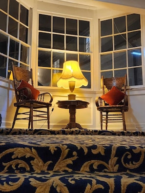 A corner room with two wooden chairs, a table with a lamp, and a patterned carpet. - The Rose and Crown Hotel (Wisbech)
