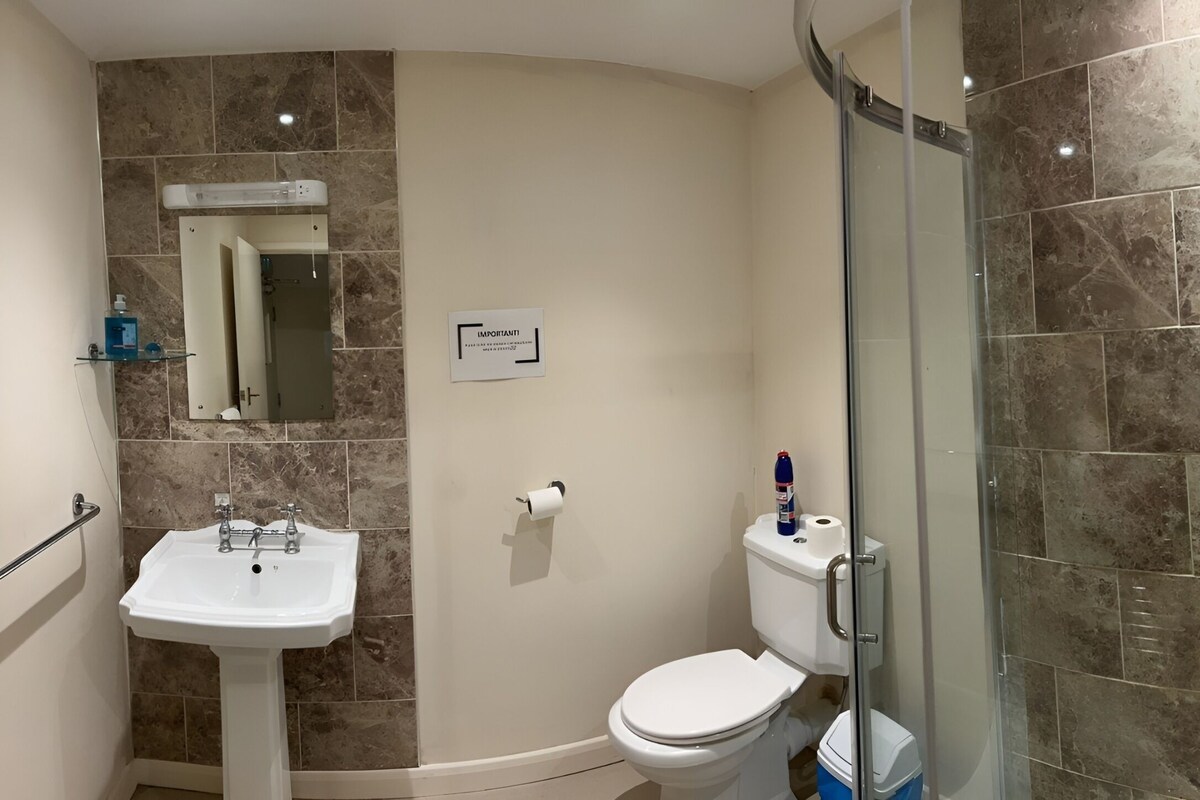 A bathroom with a sink, toilet, and shower.