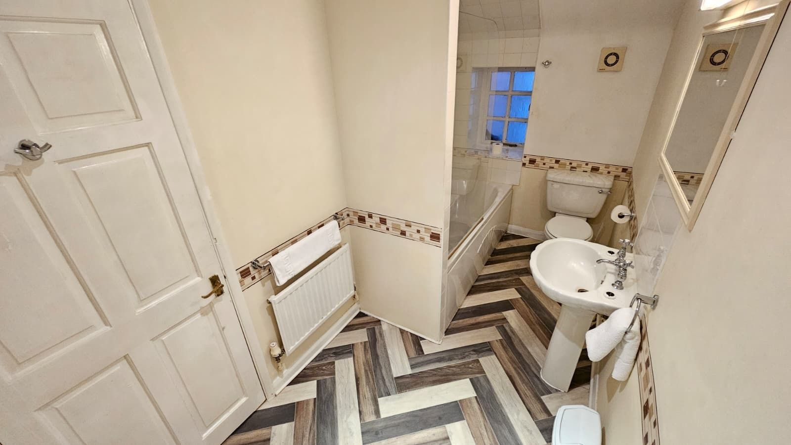 Un baño con un radiador blanco, un lavabo y un inodoro.