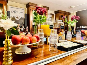 A coffee bar area with a menu, fruit display, and beverage dispensers. - The Rose and Crown Hotel (Wisbech)
