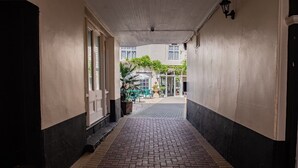 A corridor with a brick floor leading to a building entrance. - The Rose and Crown Hotel (Wisbech)