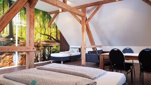 Une chambre avec une grande fenêtre, un lit, un bureau et une chaise.
