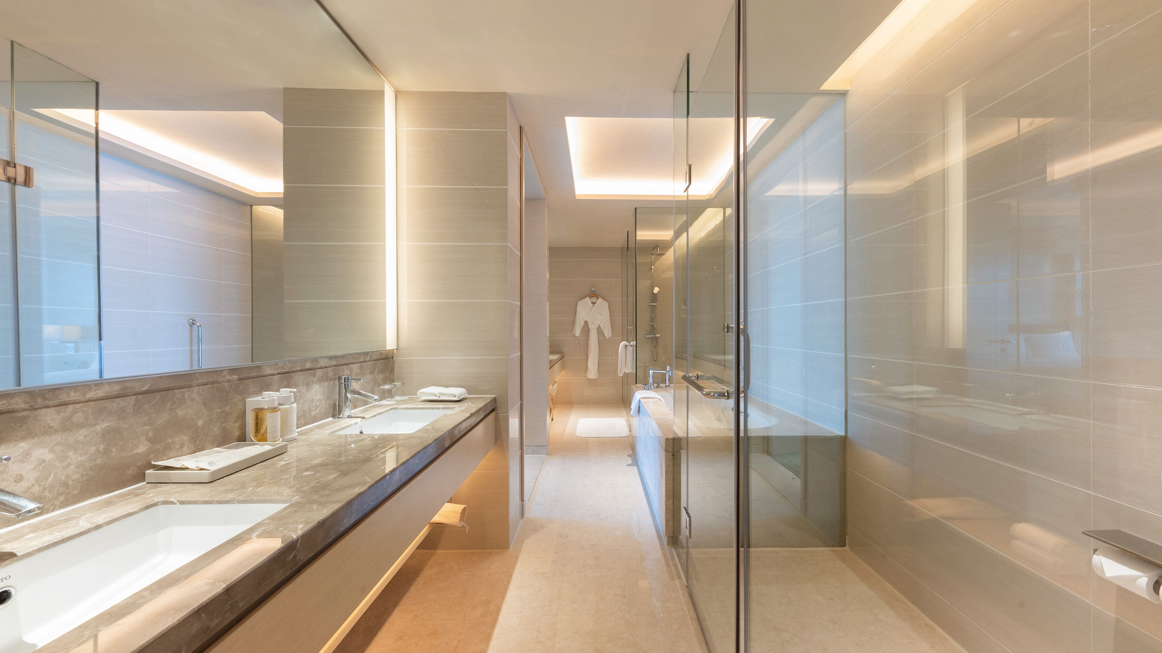 A modern bathroom with two sinks, a glass shower enclosure, and a walk-in shower.