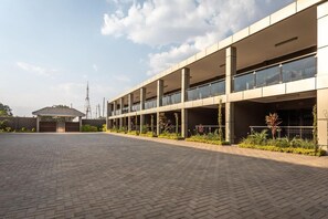 A multi-story building with a covered parking area and a small pavilion. - Fallsway Suites (Lusaka)