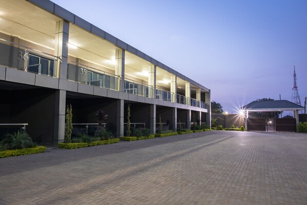 A modern building with a covered outdoor area and a paved walkway. - Fallsway Suites (Lusaka)