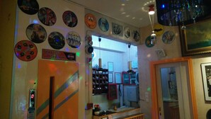 Una habitación con una pared decorada con varios objetos circulares, un letrero de Harley-Davidson y un espejo que refleja la habitación.
