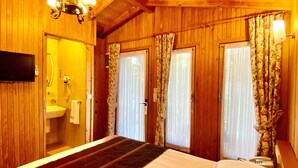 A wooden room with a bed, a mirror, a sink, and a shower. - Kayezta Hotel Alacati (Cesme)