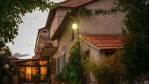 Il s’agit d’un bâtiment traditionnel doté d’une façade en pierre, d’un toit recouvert de tuiles en terre cuite et d’un petit balcon. On y trouve des plantes en pot et une entrée bien éclairée.