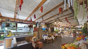 Un restaurant au décor rustique, avec des murs en pierre, des poutres en bois et une variété de fruits et de légumes disposés sur les tables.