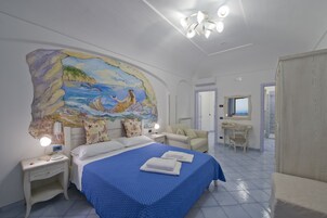 Una habitación de hotel con cama, escritorio, silla y un gran mural en la pared.