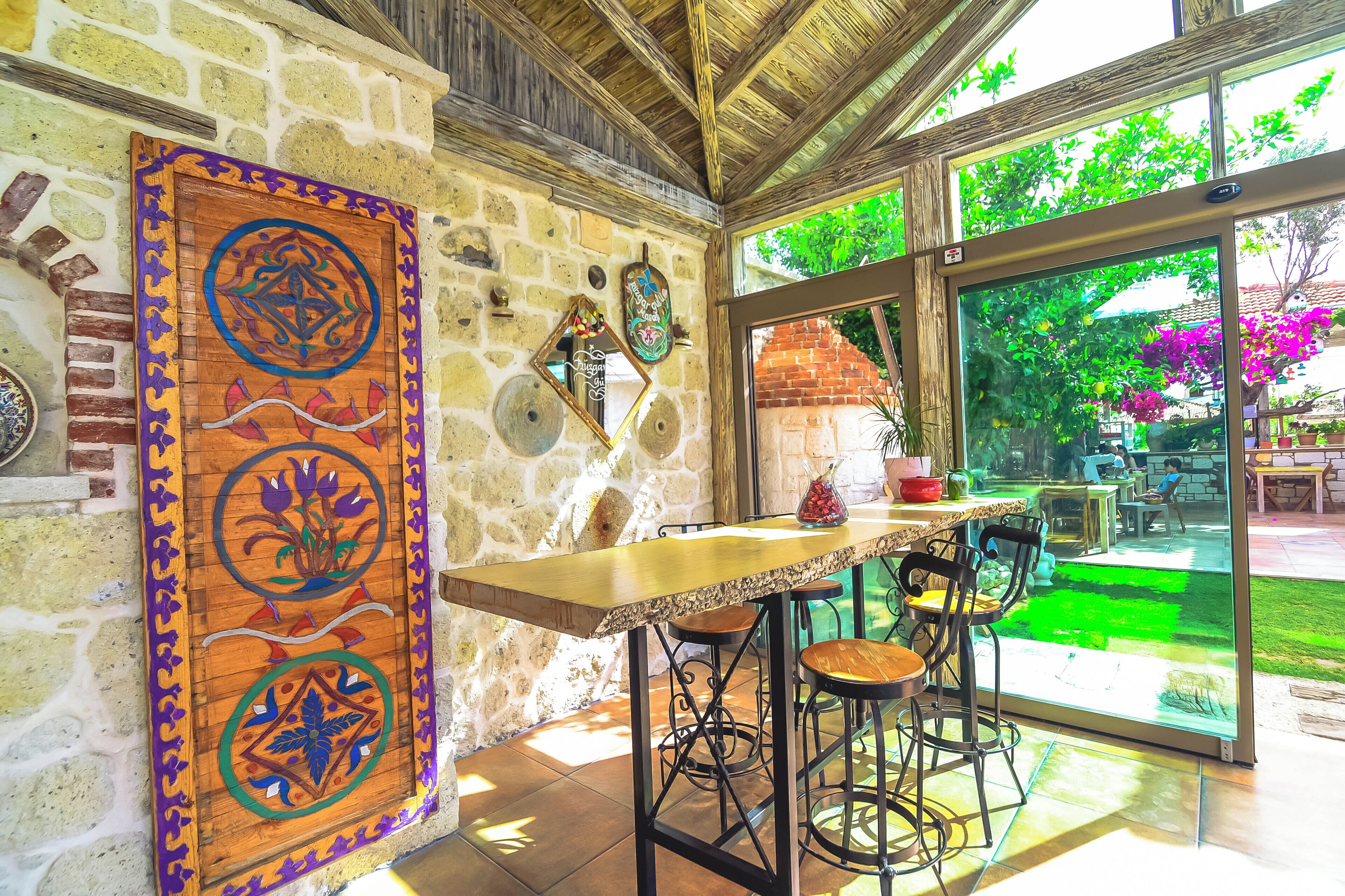 A rustic stone wall with a wooden panel featuring intricate designs.