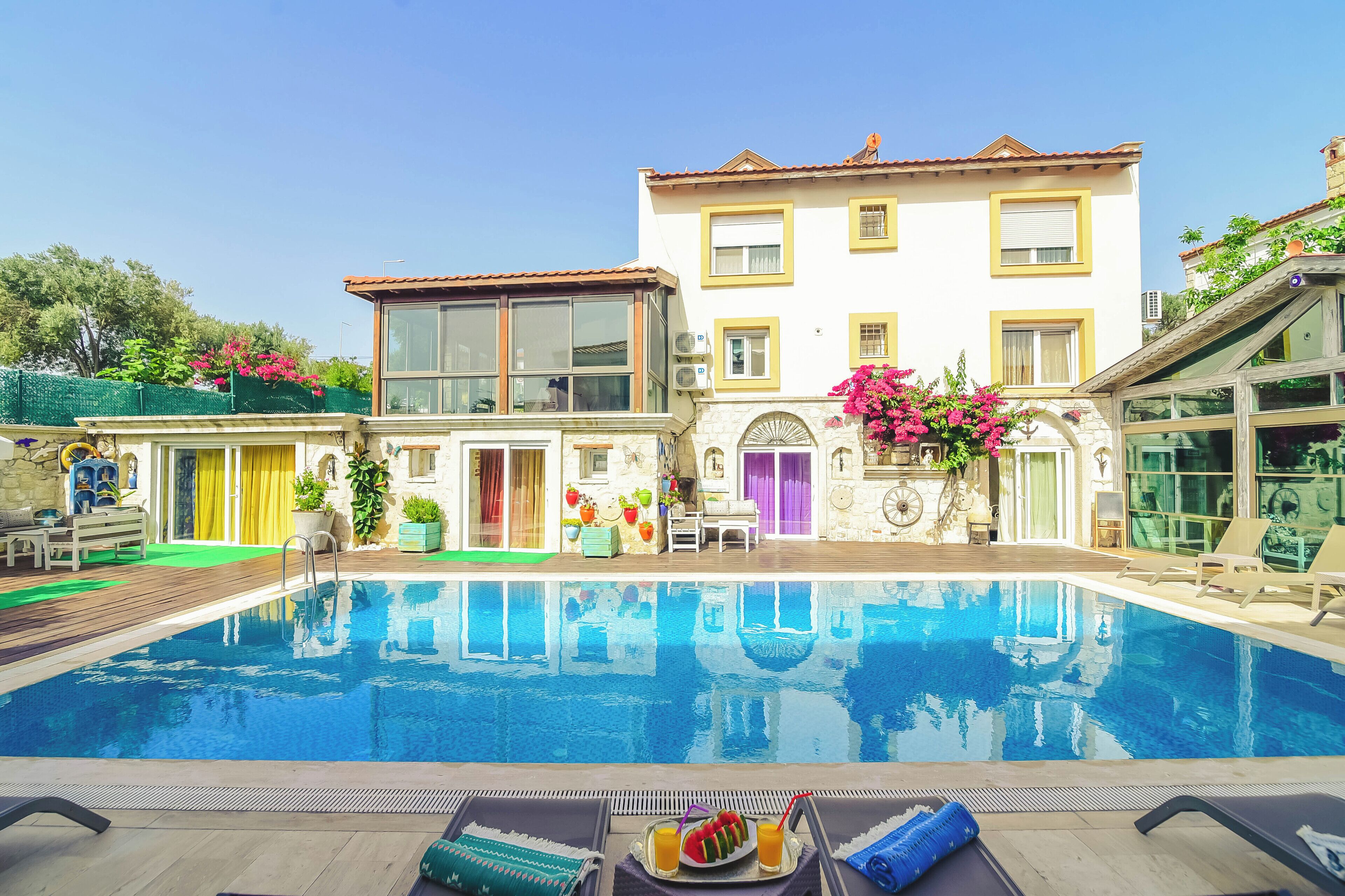 A swimming pool with lounge chairs and a dining setup.