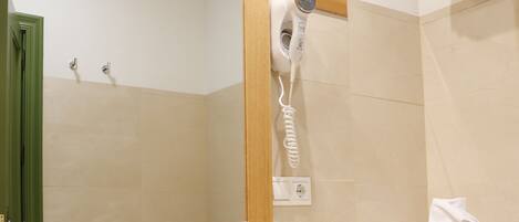 A bathroom with a sink, mirror, towel rack, and a hairdryer.